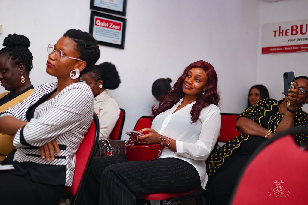 Women seated in a row, listening to a session