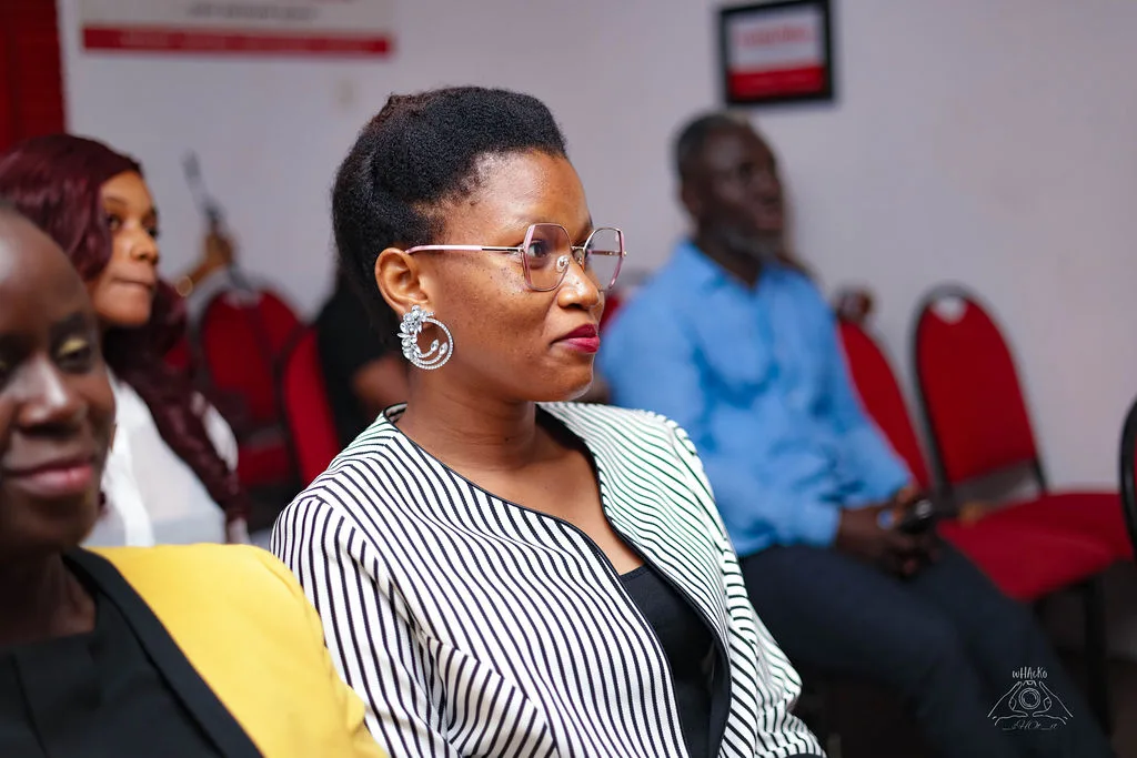 A woman in the audience listening closely, seen in profile