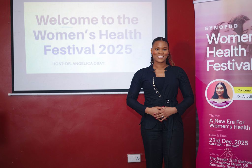 A woman presenting beneath a slide reading Welcome to the Women's Health Festival